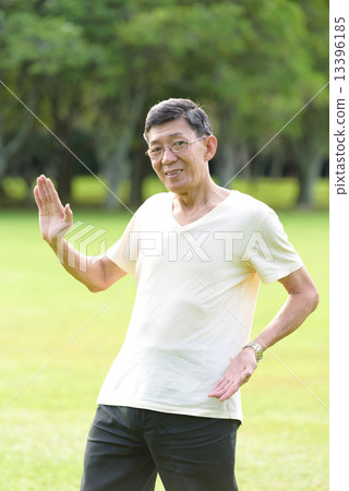 One male chinese elderly doing morning exercise in an open field in the park 13396185