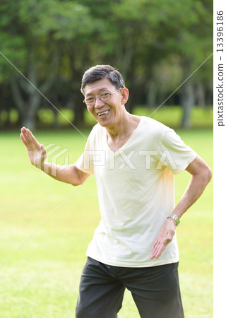 One male chinese elderly doing morning exercise in an open field in the park 13396186