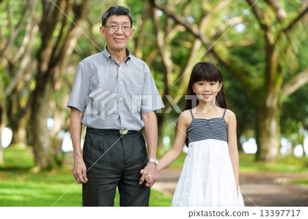 Chinese granddaughter and grandfather having a walk in the park 13397717