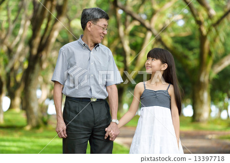 Chinese granddaughter and grandfather having a walk in the park 13397718