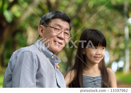 Chinese granddaughter and grandfather in a park 13397962
