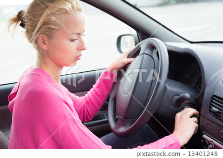 Female car driver starting the engine. Female car driver starting the engine. 13401248