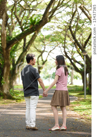 Back view of chinese couple walking in a park Back view of chinese couple walking in a park 13437365
