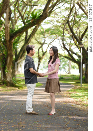 Chinese couple holding hands in a park 13437367