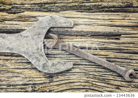 Vintage metallic spanners on old wooden table Vintage metallic spanners on old wooden table 13443636
