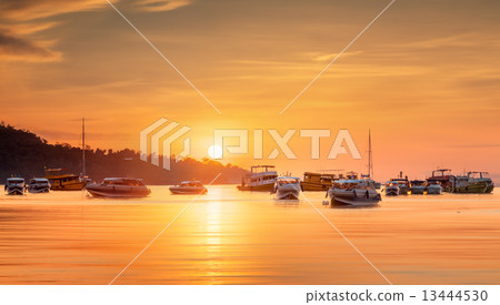 sunrise with colorful sky and boats on the beach 13444530