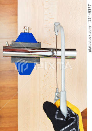 metalworker sawing trap pipe gripped in vice metalworker sawing trap pipe gripped in vice 13449577