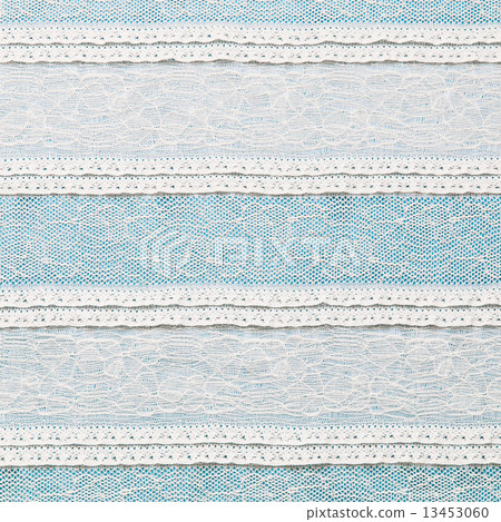 Ivory lace fabric on blue background 13453060