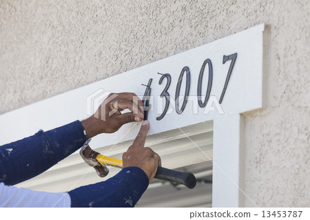 House Painter Contractor Nails Address Numbers to House Facade House Painter Contractor Nails Address Numbers to House Facade 13453787