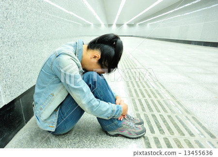 disappointed woman sit on the passage of subway station disappointed woman sit on the passage of subway station 13455636