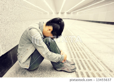 disappointed woman sit on the passage of subway station disappointed woman sit on the passage of subway station 13455637