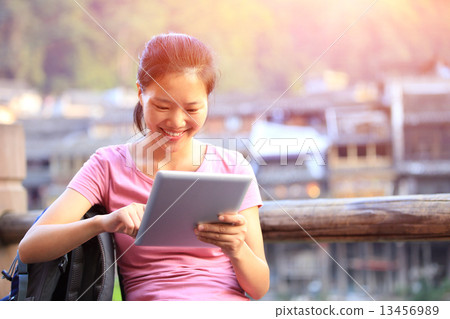 young asian woman use tablet pc at fenghuang ancient town,china young asian woman use tablet pc at fenghuang ancient town,china 13456989