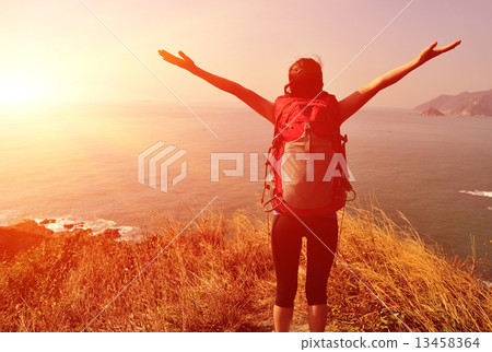 hiking woman stand mountain peak looking at the view with arms open  13458364