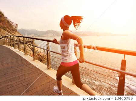 healthy lifestyle sports woman running on wooden boardwalk seaside  13460799