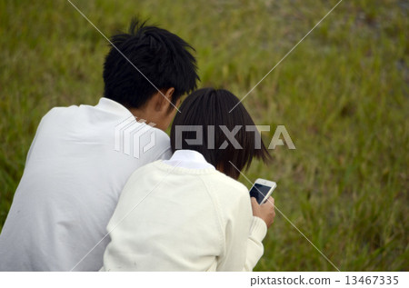 A couple playing with a smartphone 13467335