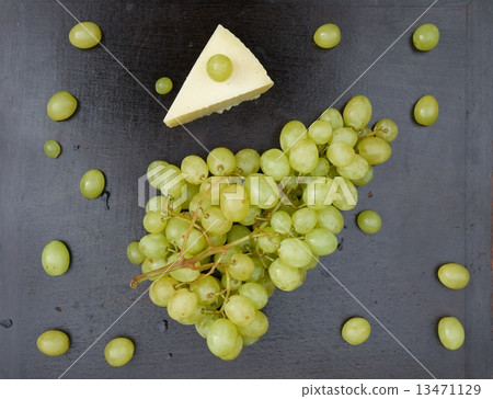 Bunch of white seedless grape and a piece of cheese 13471129