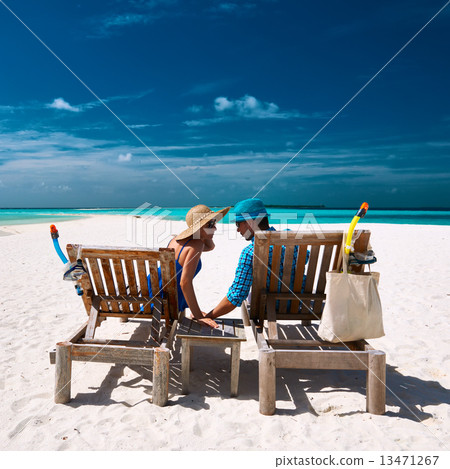 Couple relax on a beach at Maldives 13471267