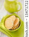 Waffles  in the green bowl with jug of milk 13471722