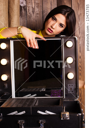 Young beautiful girl visagist near cosmetic table 13473785