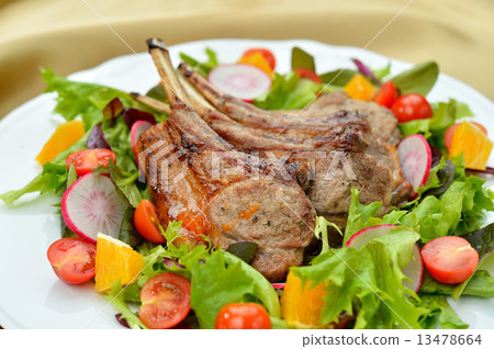 Grilled chicken with lamb with bone. Served with salad. Grilled chicken with lamb with bone. Served with salad. 13478664