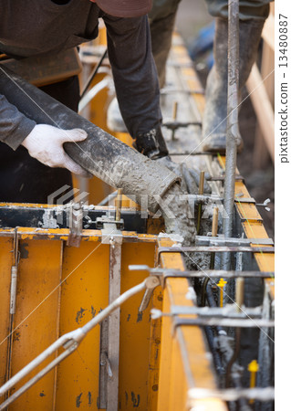 Concrete placing on raw foundation construction frame of housing 13480887