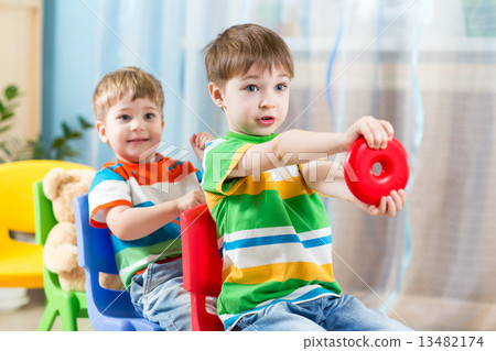 Kids riding on carriages made from chairs  13482174