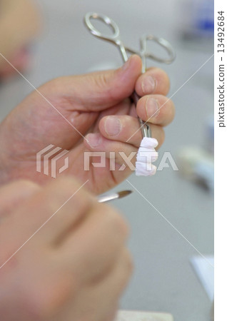 Dental technician working in a lab 13492684