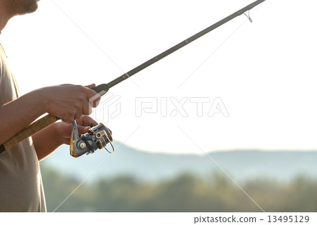 Modern clean fishing rod in hands Modern clean fishing rod in hands 13495129