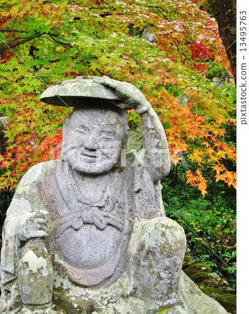 Mr. Daito sitting in autumn leaves and a barrel of fall autumn 13495763