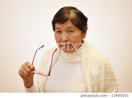 A woman in her 60s who takes off glasses A woman in her 60s who takes off glasses 13499201