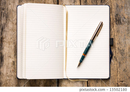 Opened empty notebook on wooden table 13502180