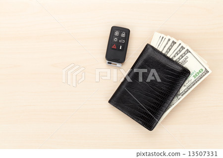 Money cash wallet and car remote key on wooden table 13507331