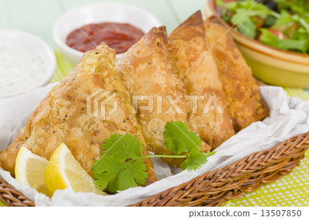 Samosas - Deep fried stuffed pasties with lemon wedges and dips  13507850