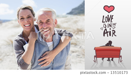 Composite image of happy hugging couple on the beach looking at 13510173