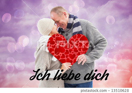 Composite image of happy mature couple in winter clothes holding 13510628