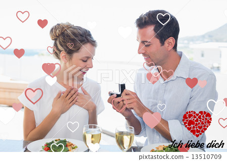 Composite image of man surprising woman with a wedding ring at l Composite image of man surprising woman with a wedding ring at l 13510709