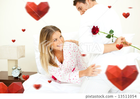 Composite image of attentive man giving a rose to his wife Composite image of attentive man giving a rose to his wife 13511054