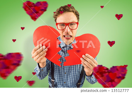 Composite image of geeky hipster holding a broken heart 13512777
