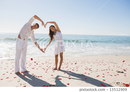 Composite image of loving couple forming heart shape with arms Composite image of loving couple forming heart shape with arms 13512909