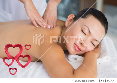 Composite image of content brunette getting a back massage 13513022