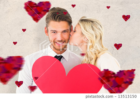 Composite image of attractive young couple holding red heart 13513150