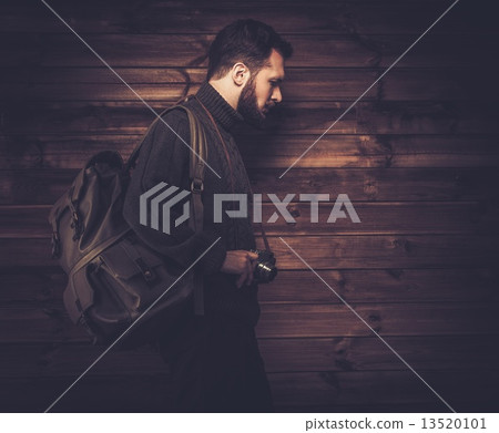 Handsome man wearing cardigan with backpack and vintage camera 13520101