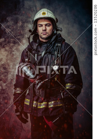Firefighter with helmet and axe in a smoke 13520286