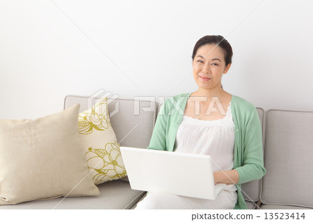 Middle-aged woman using a personal computer 13523414