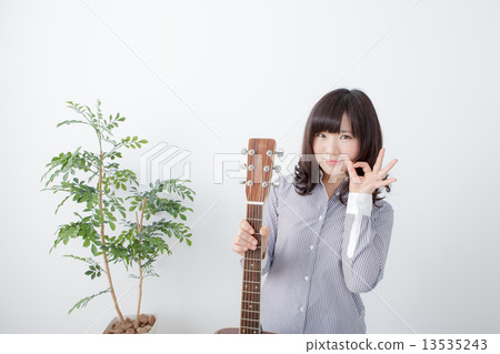 A young woman holding a guitar A young woman holding a guitar 13535243