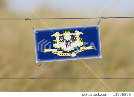 Border fence - Old plastic sign with a flag 13536899