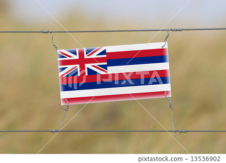 Border fence - Old plastic sign with a flag Border fence - Old plastic sign with a flag 13536902