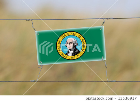 Border fence - Old plastic sign with a flag Border fence - Old plastic sign with a flag 13536917