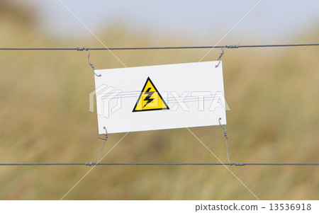 Border fence - Old plastic sign with a flag 13536918
