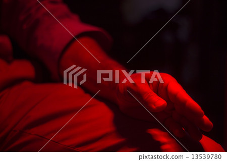 Hand of patient under red rehabilitation clinic heat lamp 13539780